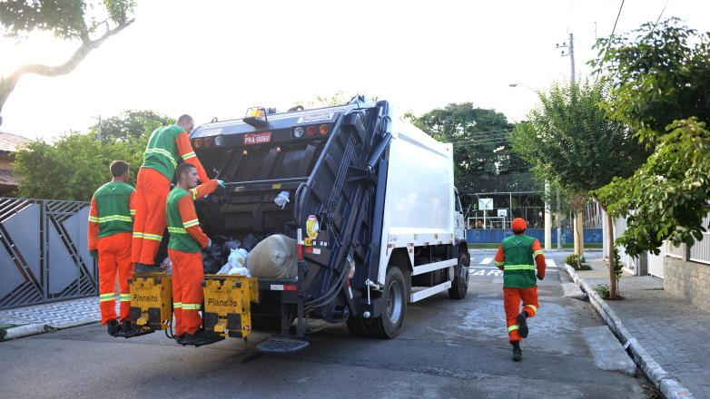 Coletores acompanham caminhão da coleta e recolhem resíduos