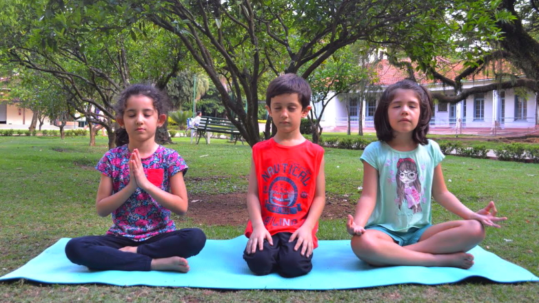 Crianças praticam ioga ao ar livre